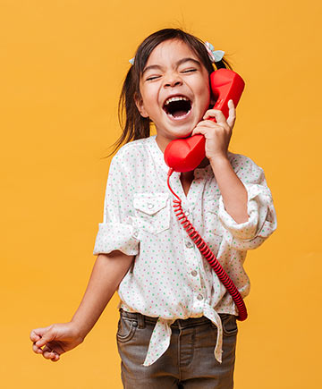 Excited girl talking on toy telephone